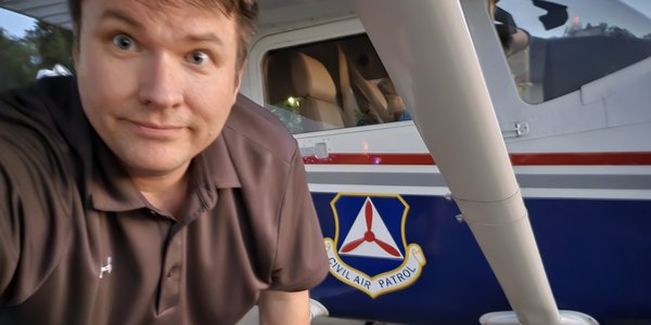 Brett under the wing of a Civil Air Patrol plane