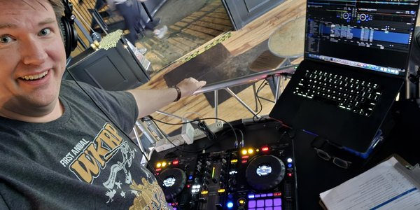 Brett smiling at his DJ controller and laptop