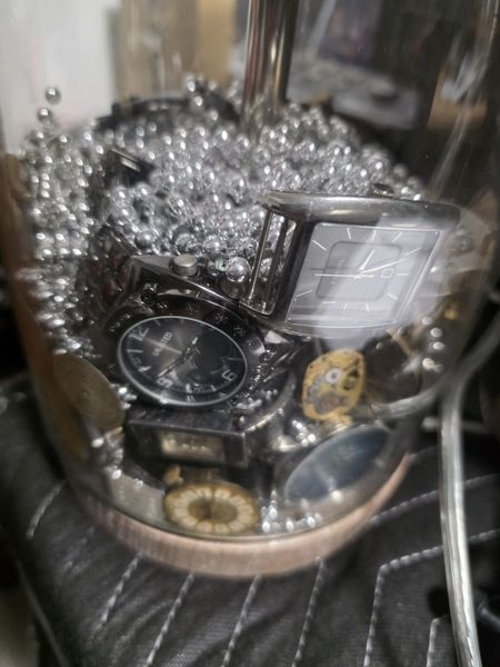 Glass lamp filled with old watches and silver beads