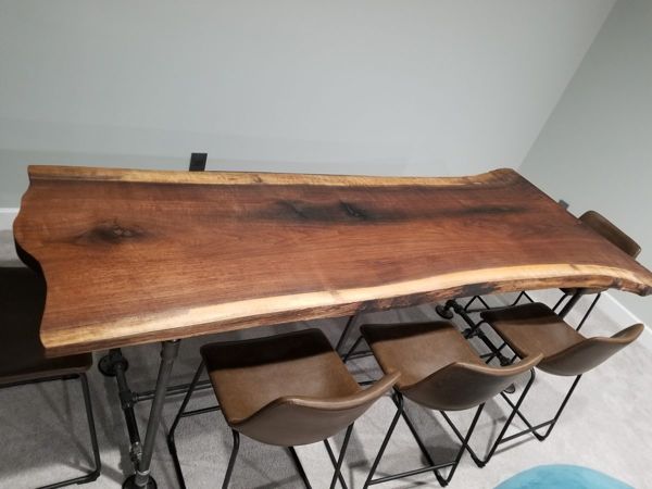 Live-edge walnut slab on a black pipe base